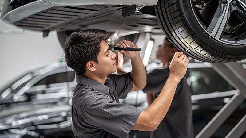 Ford service technician inspecting vehicle tire